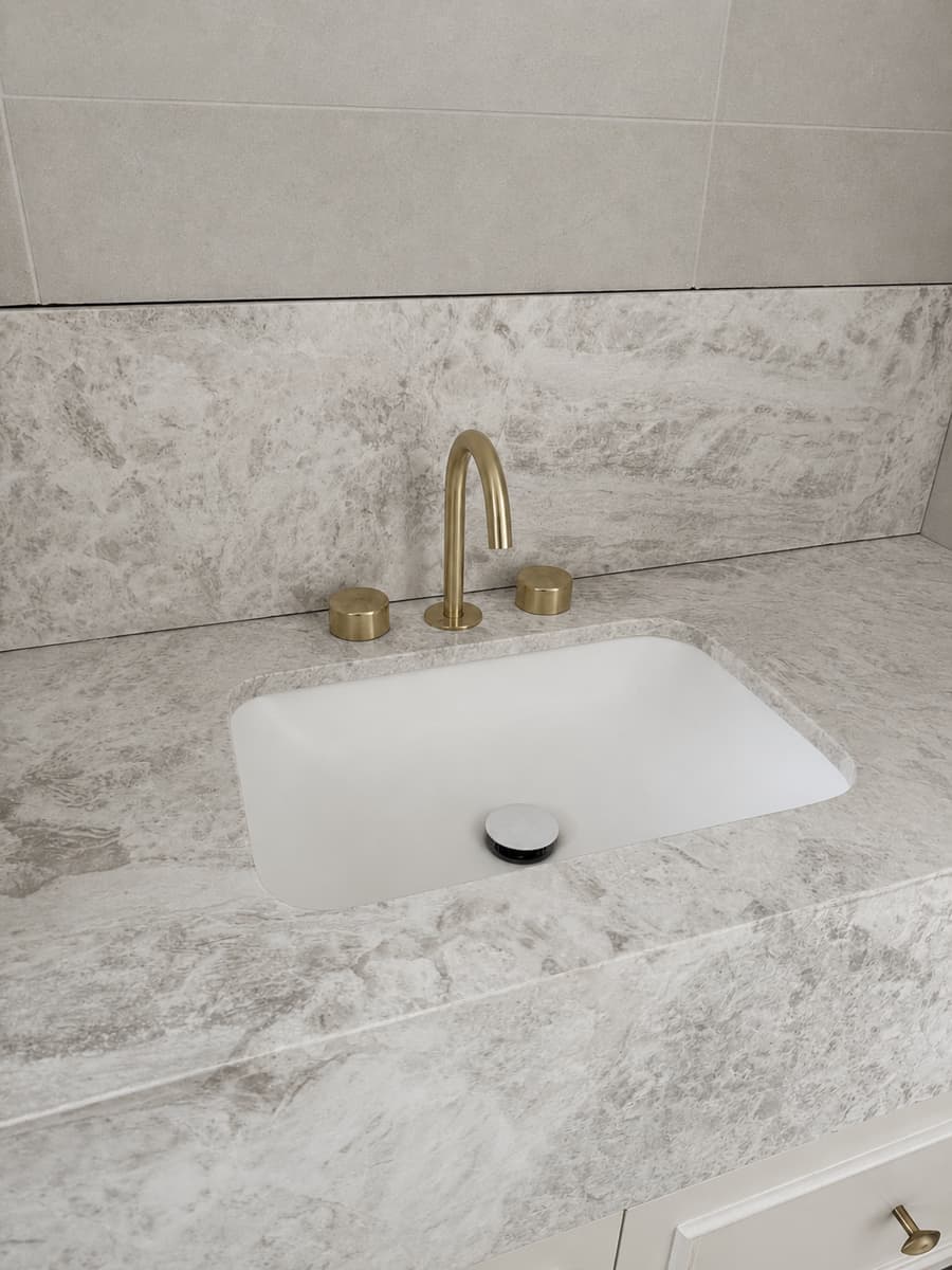 Finished bathroom vanity installation with marble-look benchtop, undermount basin and matte black tapware